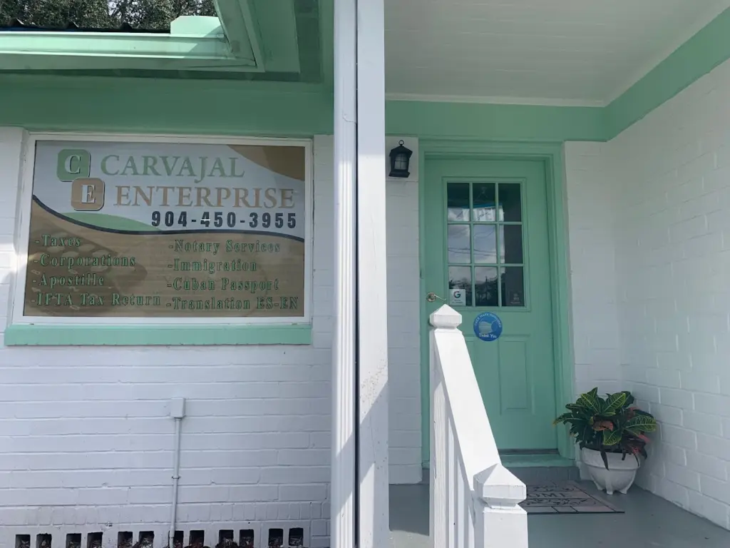 Entrada de la oficina de Carvajal Enterprises en Jacksonville, Florida, con su logotipo, información de contacto y servicios de notaría, impuestos y gestión documental.